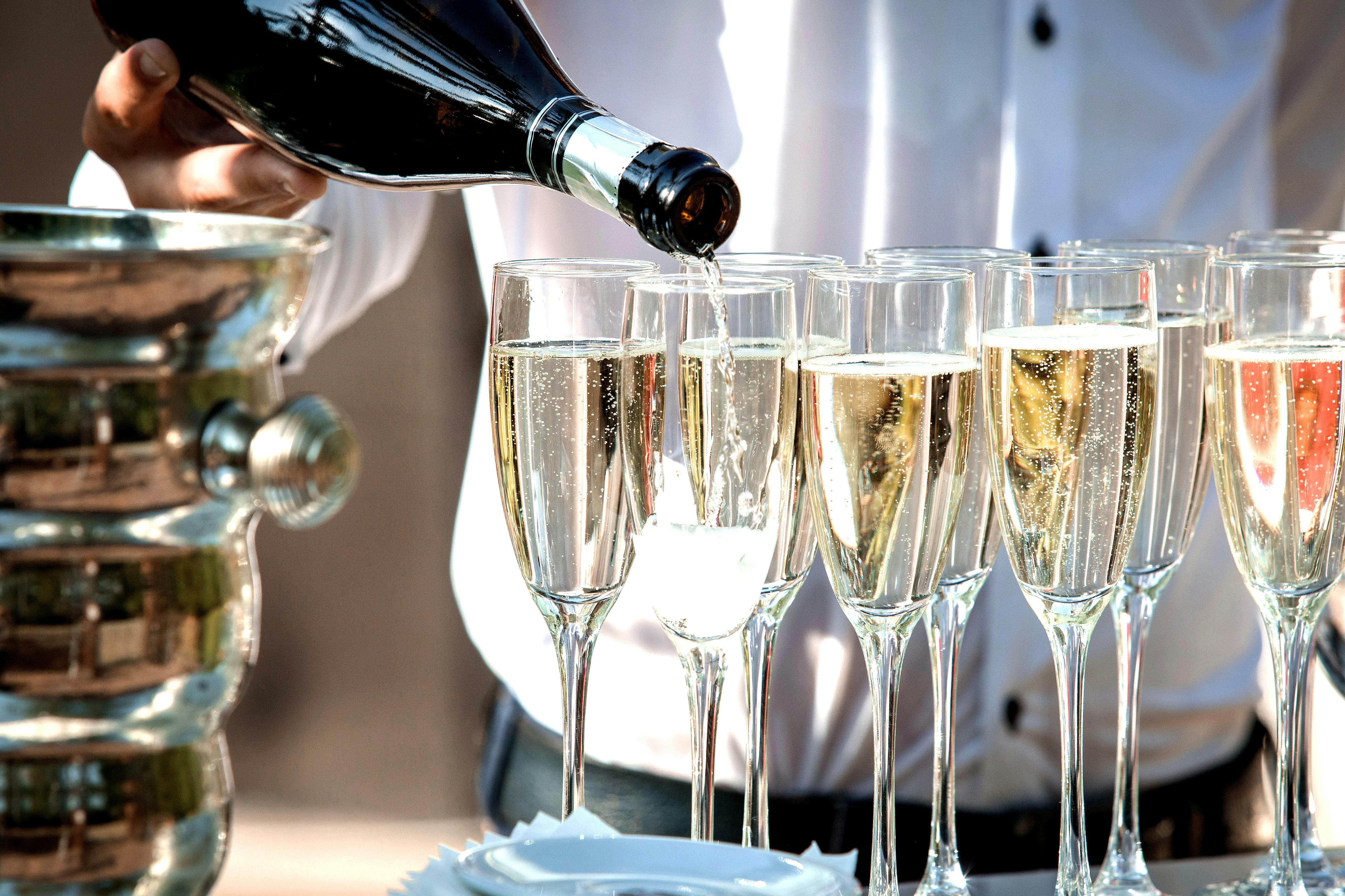 Close-up of champagne pouring into glasses at a festive event.